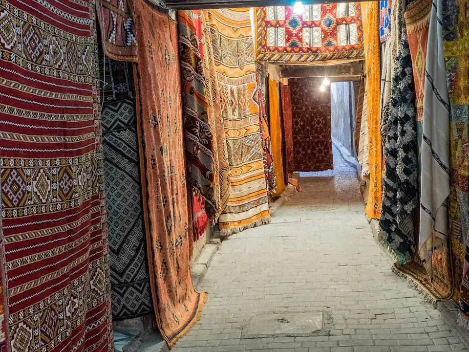 İki yanı rengârenk kilim ve halılarla kaplı dar bir çarşı sokağı